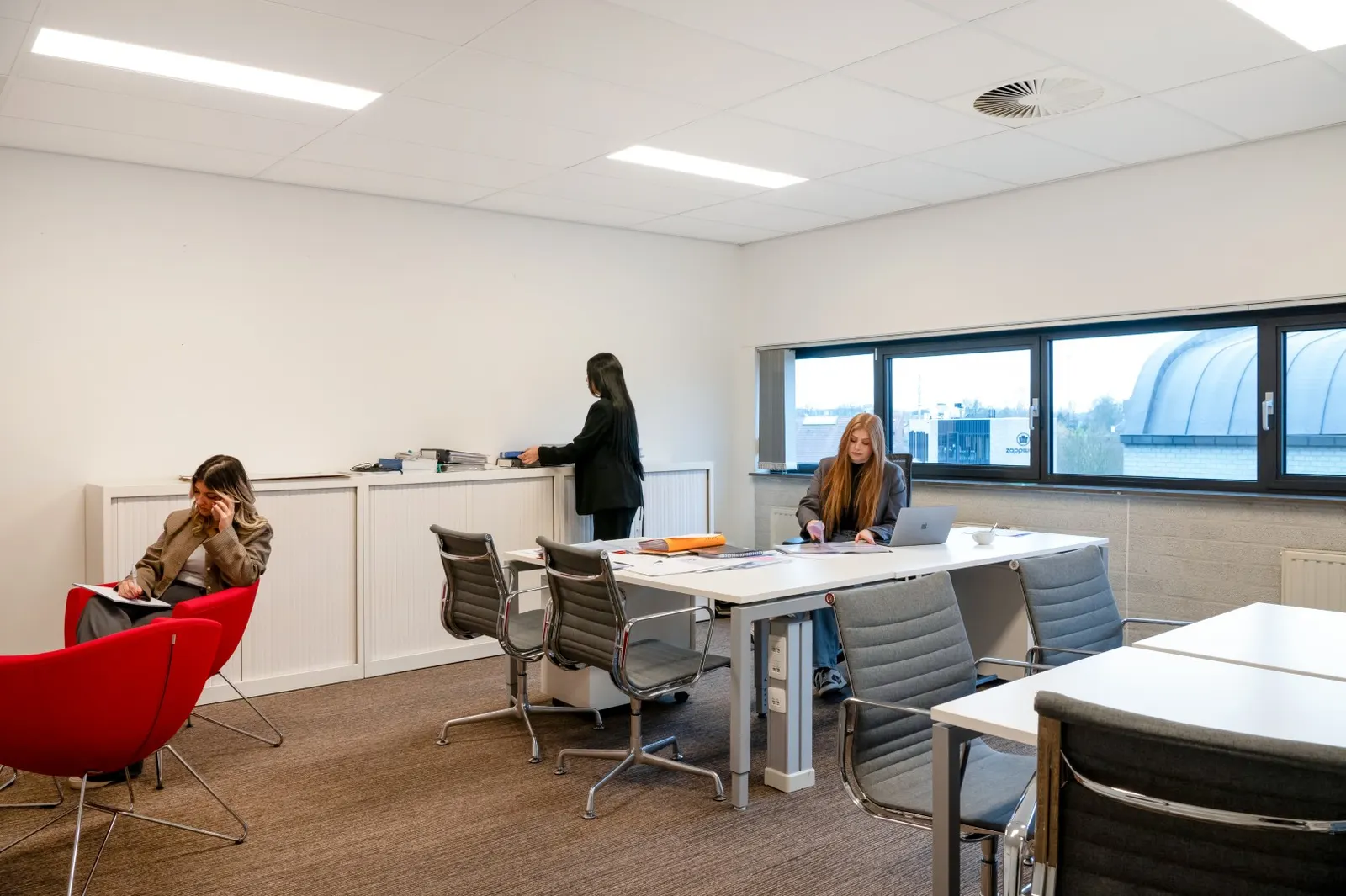 Open werkruimte met bureaus waar mensen aan het werk zijn in Office Capital Hasselt