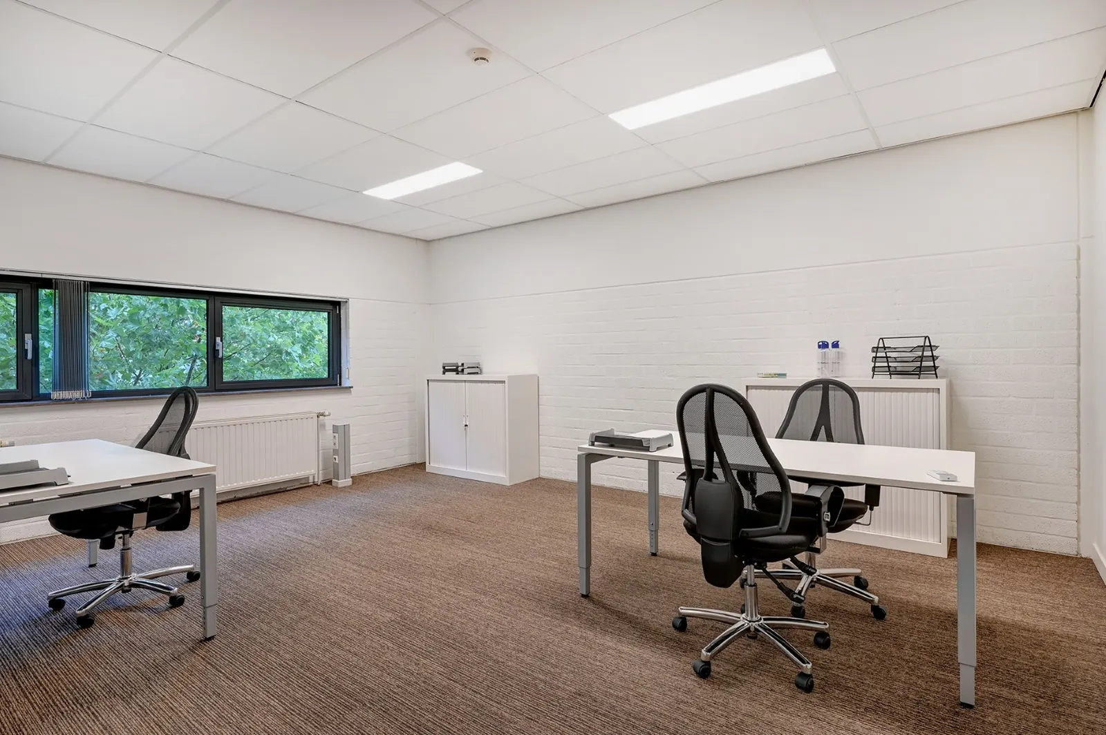 Leeg kantoor met drie bureaus en bureaustoelen, klaar voor inrichting naar keuze, in Office Capital Hasselt