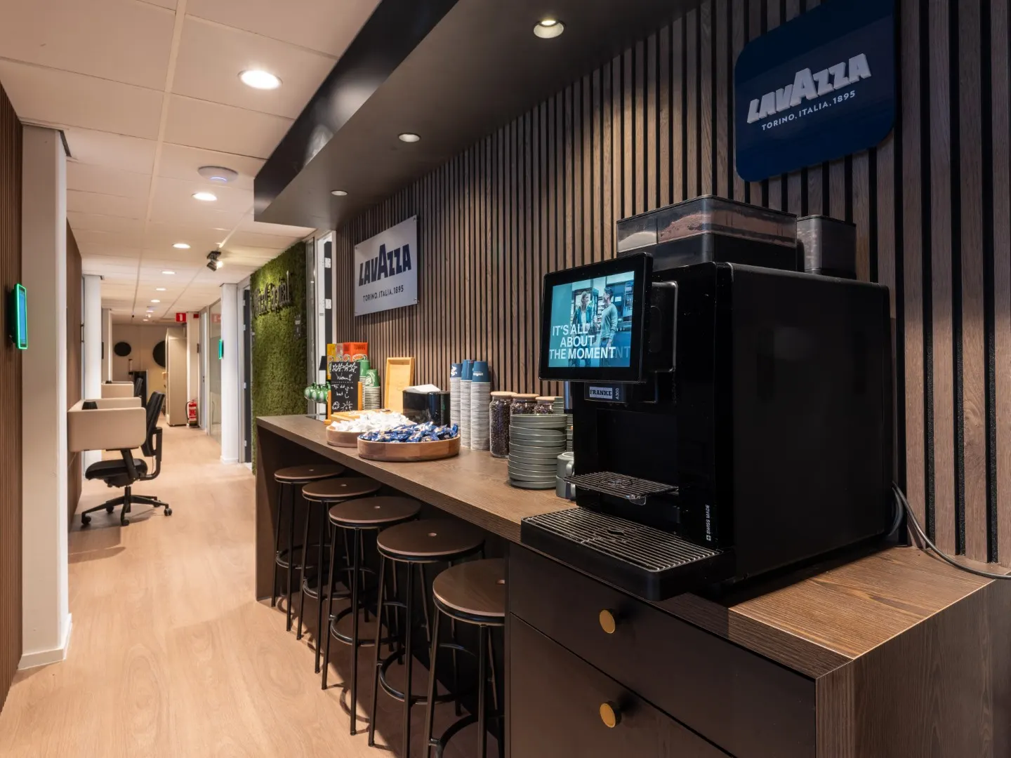 Gang met werkplekken langs de Lavazza koffiecorner in Office Capital Maastricht-Airport
