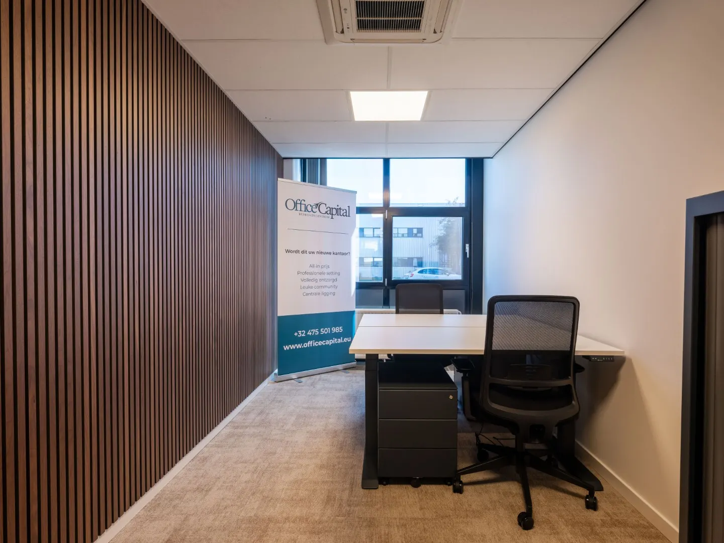 Kantoor met houten lamellenwand, bureau en ergonomische bureaustoel in Office Capital Maastricht-Airport