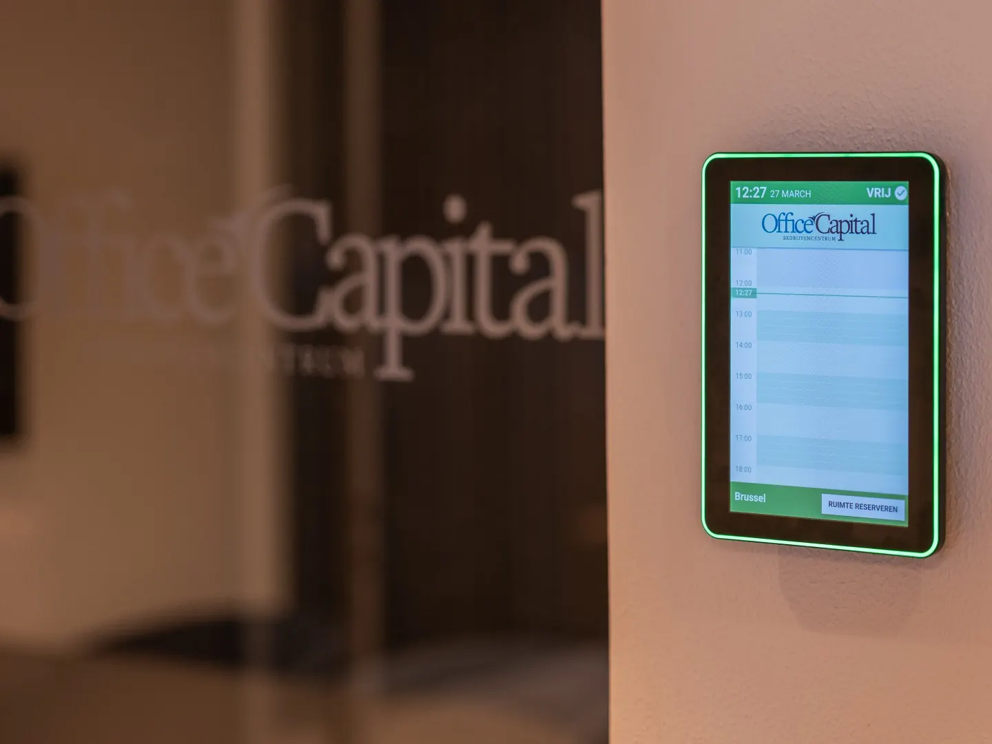 Slim scherm naast een vergaderruimte toont de reserveringen in Office Capital Maastricht-Airport